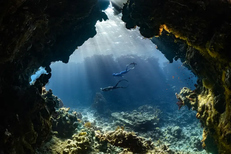 Scuba divers exploring an underwater cave