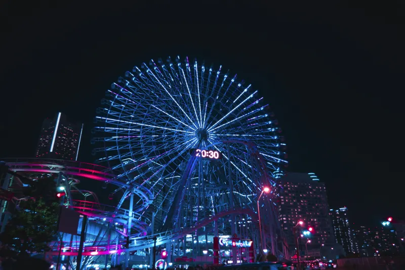 Theme park rides lit up with colourful lights at night