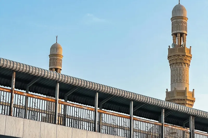 Ajman corniche bridge and mosque minaret under a blue sky
