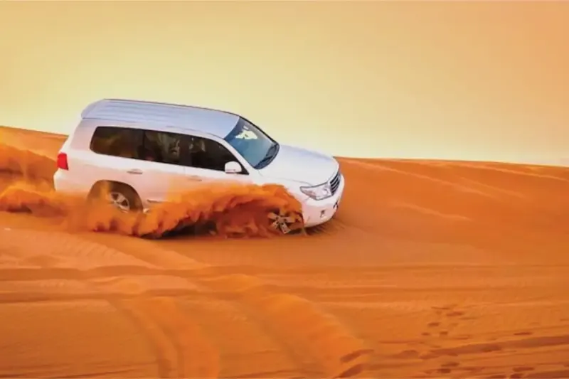 Land Cruiser dune bashing on the red dunes during an evening desert safari in Dubai
