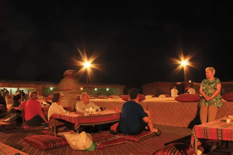 Guests relaxing at a Bedouin desert camp in Dubai at night