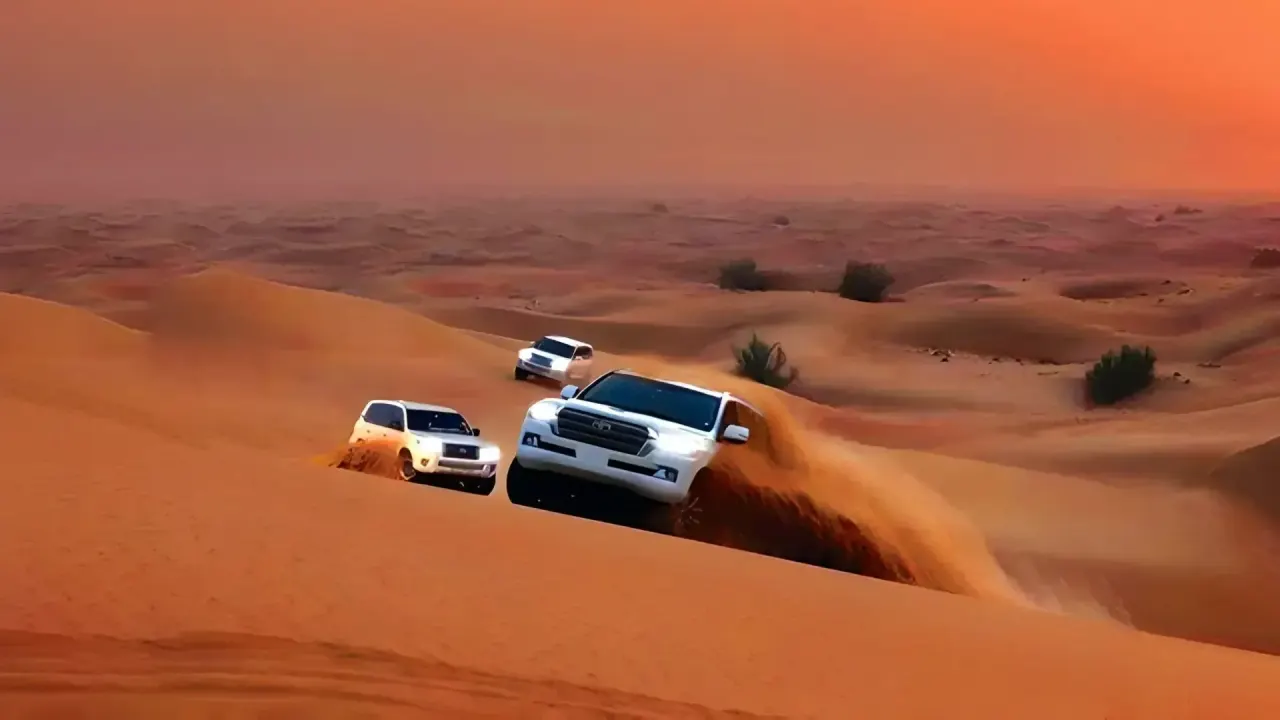 Land Cruisers dune bashing on the red dunes in Dubai